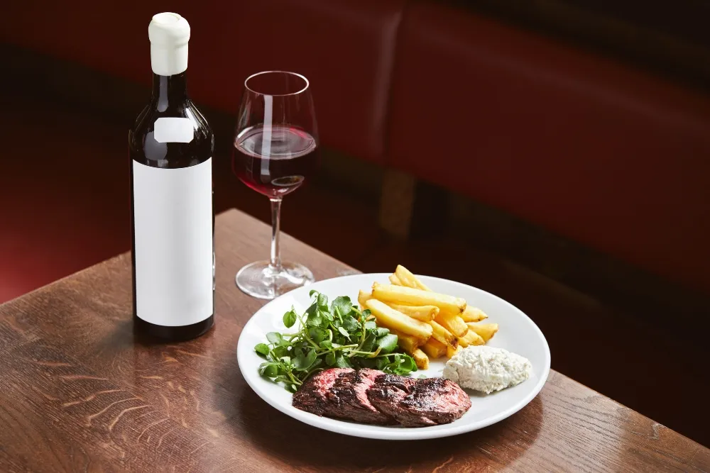 bottle of red wine and steak in restaurant