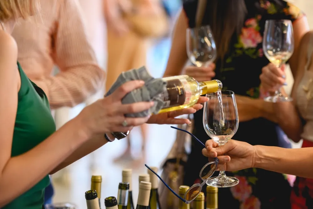 a woman pouring wine into the wine glass