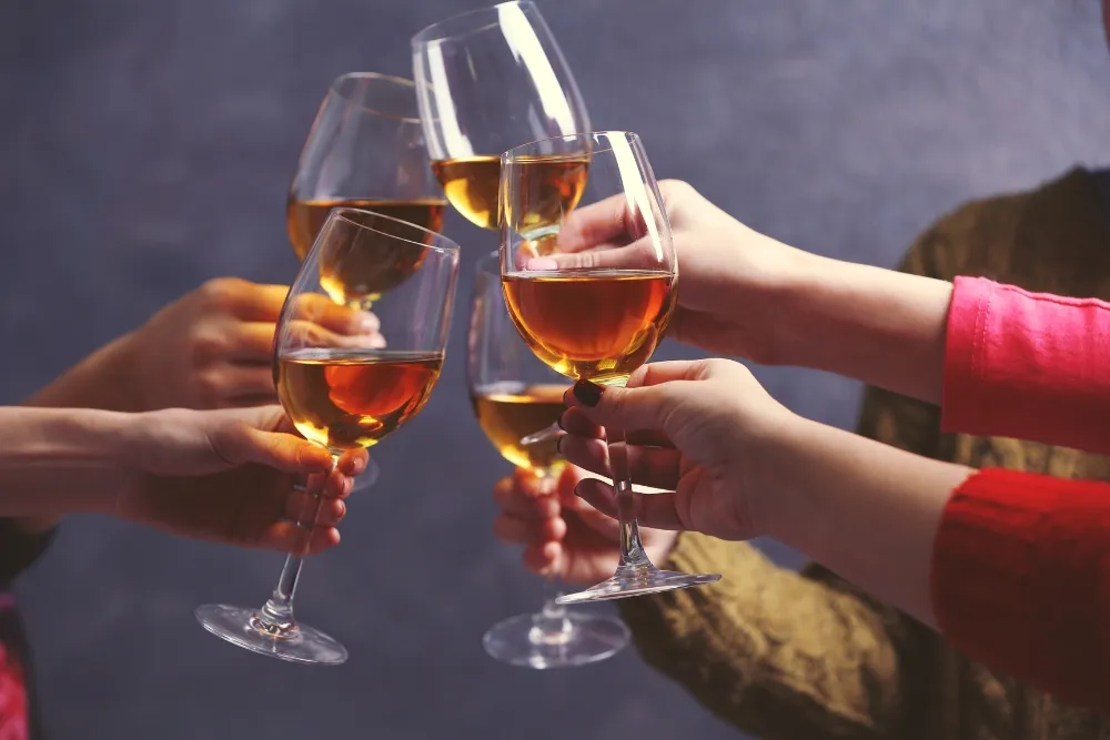 people doing cheers with wine glass