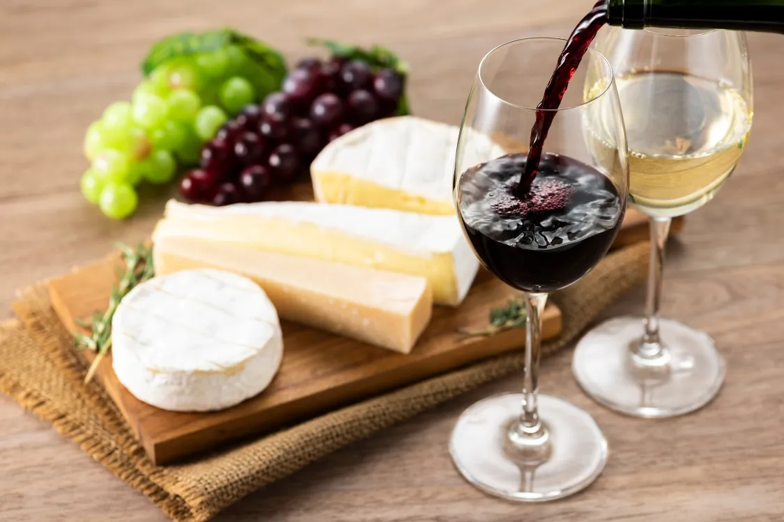 glasses of wine and a cheese and grapes
